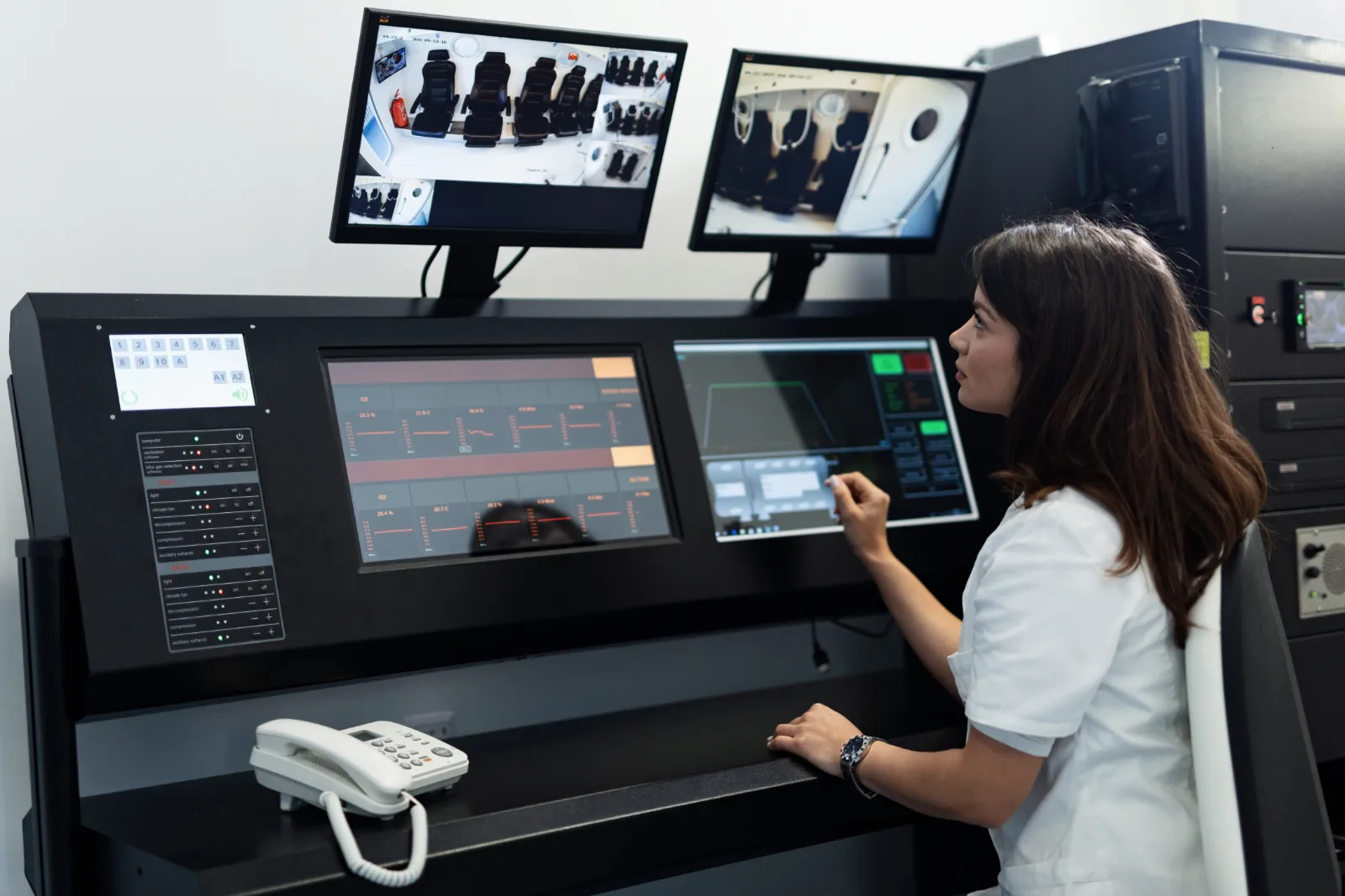 woman-works-at-control-station-with-monitors-2026-01-06-10-27-19-utc Clinician working at a treatment control station with multiple monitors